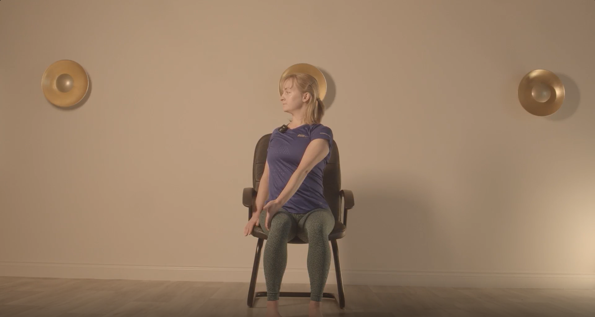 Instructor performing one of our hernia rehabilitation exercises, seated in a chair.